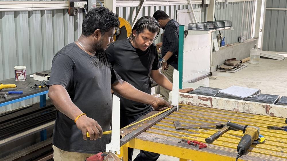 Two builders working a frame together on the bench.